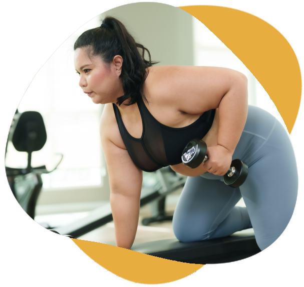 Plus size Focused female performing dumbbell rows dedication to workout