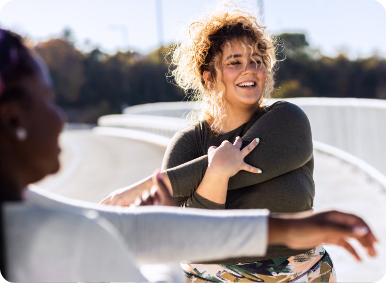 Two-young-plus-size-women-stretching-together-before-runnung. Two young plus size women stretching together before running