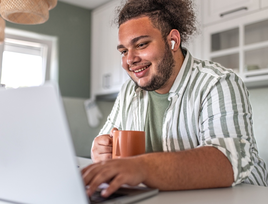 Young-smiling-man-with-headphones-typing-on-laptop-keyboard-1504469296_8023x5351